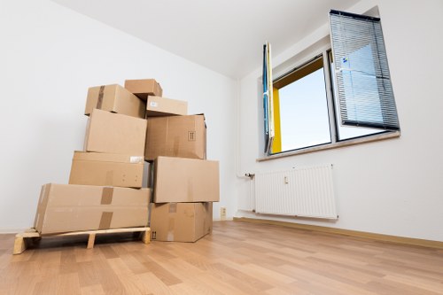 Removal team carrying boxes through a narrow Shoreditch stairwell